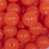 Close up view of a pile of 20mm Orange Glow in the Dark Bubblegum Beads