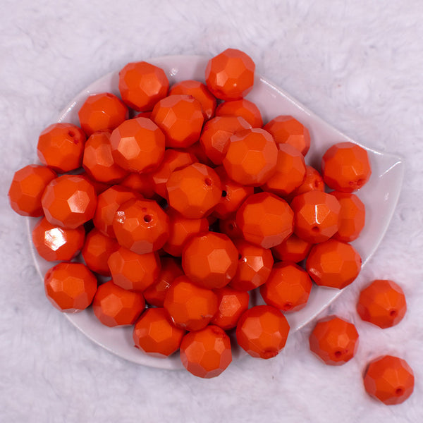 Close up view of a pile of 20mm Orange Faceted Opaque Bubblegum Beads