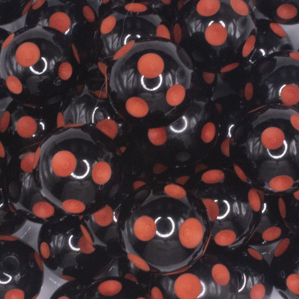 close up view of a pile of 20mm Orange Polka Dots on Black Bubblegum Beads