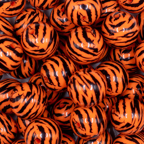 Close up view of a pile of 20mm Orange and Black Tiger Animal Print Acrylic Bubblegum Beads