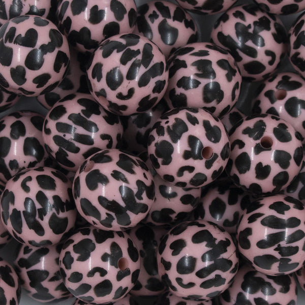 Close up view of a pile of 20mm Pink & Black Cow Animal Print Acrylic Bubblegum Beads