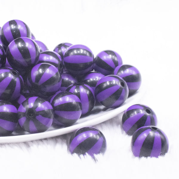front view of a pile of 20mm Purple with Black Stripe Beach Ball Bubblegum Beads