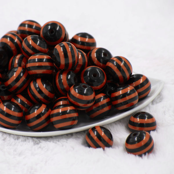 Front view of a pile of 20mm Orange & Black Stripe Acrylic Chunky Bubblegum Beads