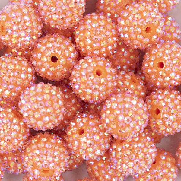 Close up view of a pile of 20mm Salmon Orange Rhinestone AB Bubblegum Beads