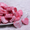 Front view of a pile of 20mm Pink and White heart shaped silicone bead