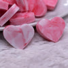 Macro view of a pile of 20mm Pink and White heart shaped silicone bead