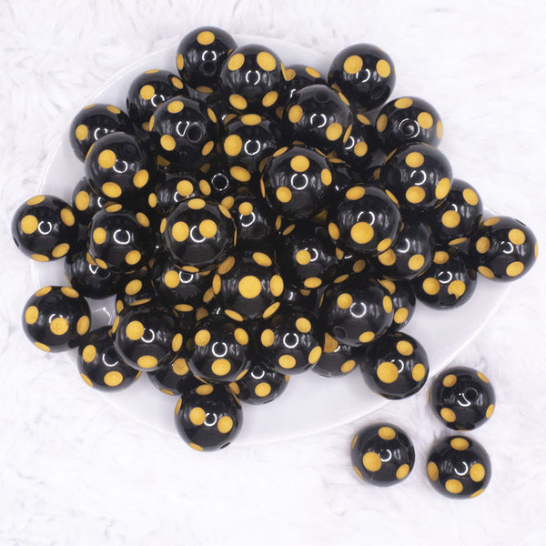 top view of a pile of 20mm Yellow Polka Dots on Black Bubblegum Beads