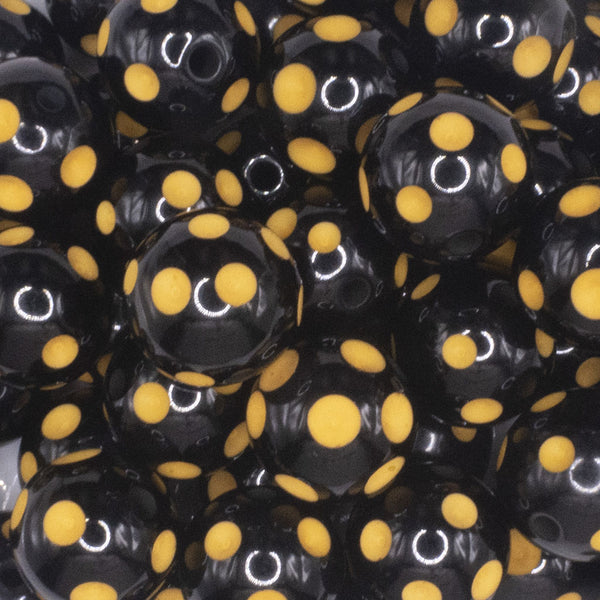 Close up view of a pile of 20mm Yellow Polka Dots on Black Bubblegum Beads