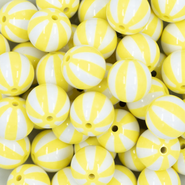 Close up view of a pile of 20mm Yellow with White Stripe Beach Ball Bubblegum Beads