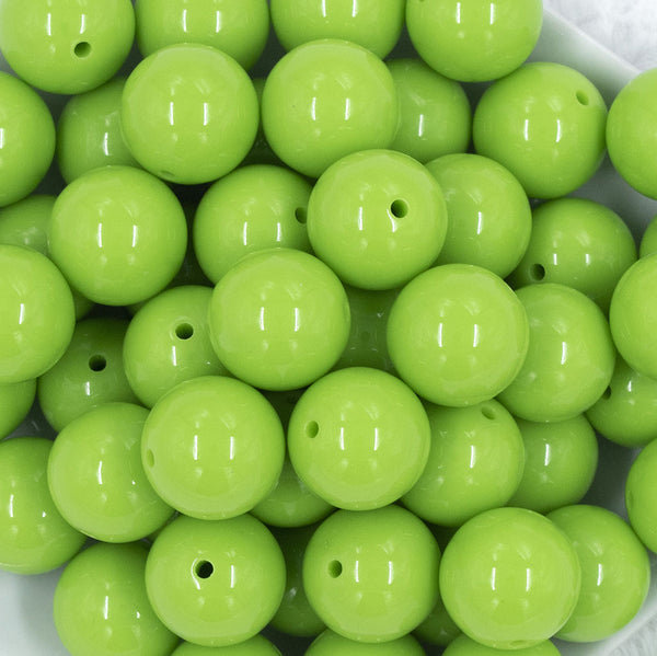 Close up view of a pile of 20mm Apple Green Solid Acrylic Chunky Bubblegum Beads