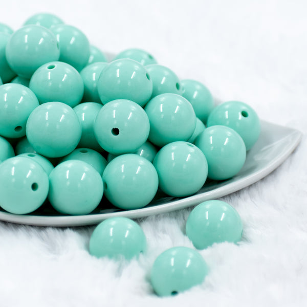 front view of a pile of 20mm Aqua Blue Solid Chunky Bubblegum Beads in white dish