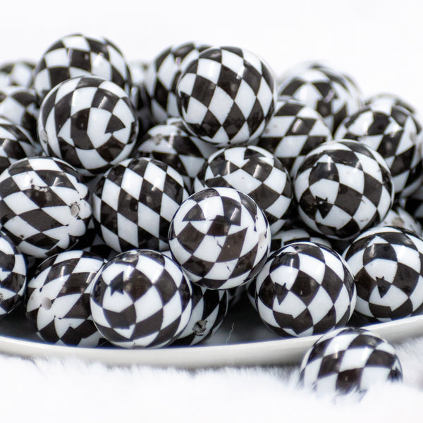 front view of many 20mm Black and White Diamond Print Chunky Acrylic Bubblegum Beads stacked in white dish