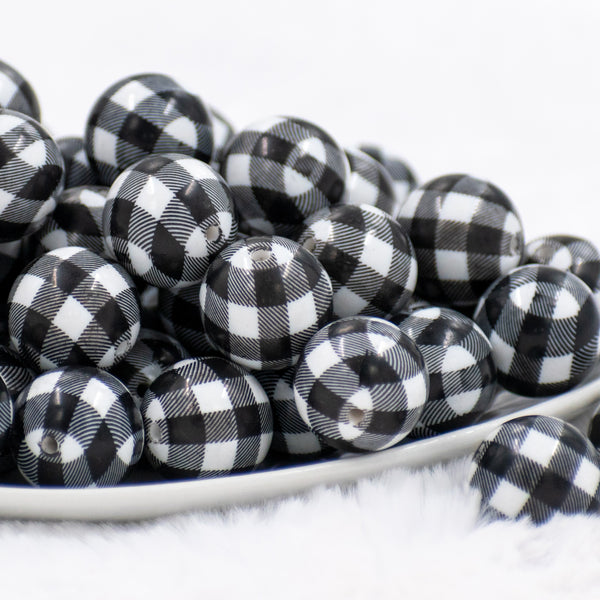 front view of a dish containing many 20mm Black & White Plaid Print Chunky Acrylic Bubblegum Beads in a white dish