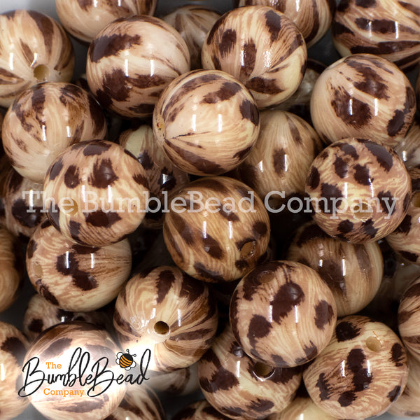 Close up view of a pile of 20mm Brown Leopard Animal Print Acrylic Bubblegum Beads with logo