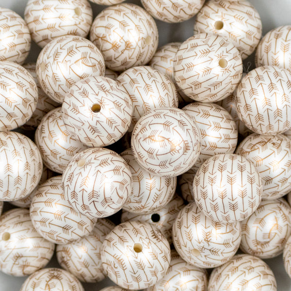 Close up view of a pile of 20mm Gold Arrows Print on White Matte Chunky Bubblegum Beads