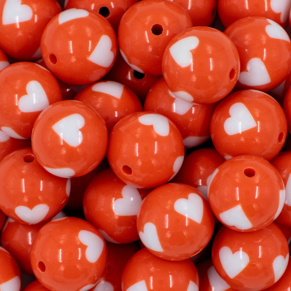 close up view of a pile of 20mm Orange with White Hearts Bubblegum Beads