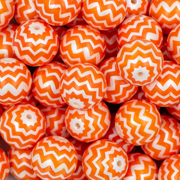 Close up view of a pile of 20mm Orange Chevron with White Matte Chunky Acrylic Bubblegum Beads