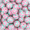 close up of a pile of 20mm Bubblegum white beads printed with pastel pink, green, and purple Flowers 