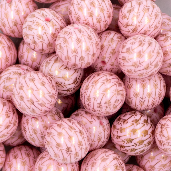 Close up view of a pile of 20mm Pink with Gold Arrows Print Chunky Bubblegum Beads