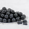 front view of 20mm Black with Silver Arrows  Print Chunky Acrylic Bubblegum Beads in a white dish