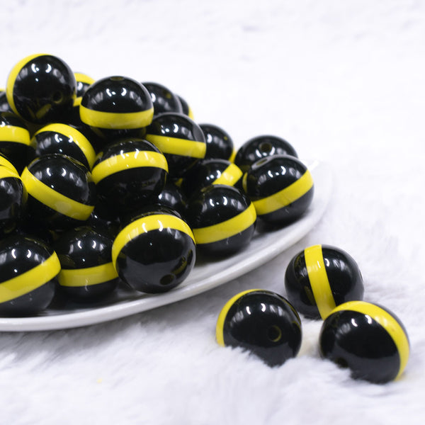 front view of a pile of 20mm Yellow Band on Black Bubblegum Beads