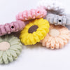 Macro view of a pile of mixed 30mm silicone daisy flower beads