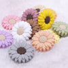 Close up view of a pile of mixed 30mm silicone daisy flower beads