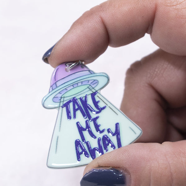 Front view of a pile Take Me Away resin charm 36x30mm