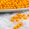 Close up front view of a pile of 4mm Mustard Yellow Pearl Spacer Beads [100-120 Count]