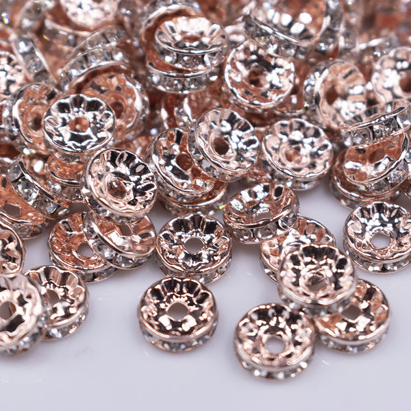 close up view of a pile of 10mm Rose Gold Rondelle Spacer Beads - Set of 20