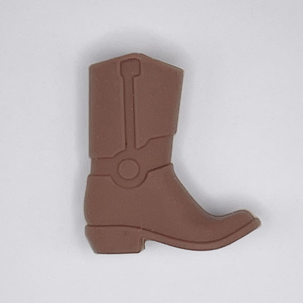top view of a pile of Brown Cowboy Boot Silicone Focal Bead Accessory - 30mm x 26mm