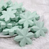front view of a pile of Mint Green Snowflake Silicone Focal Bead Accessory - 40mm x 40mm