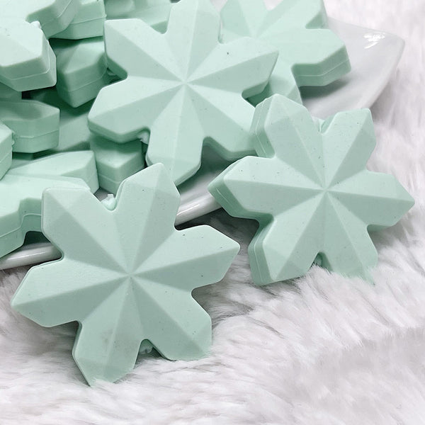 macro view of a pile of Mint Green Snowflake Silicone Focal Bead Accessory - 40mm x 40mm