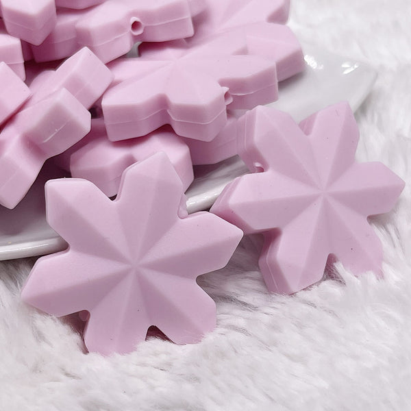 macro view of a pile of Pink Snowflake Silicone Focal Bead Accessory - 40mm x 40mm