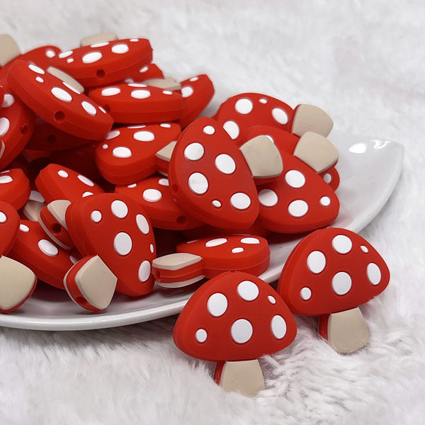 front view of a pile of Red Mushroom Silicone Focal Bead Accessory - 30mm x 29mm