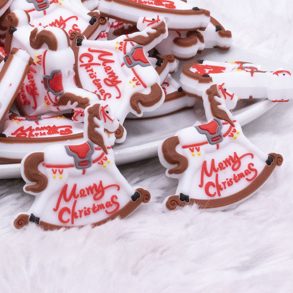 Close up view of a pile of Merry Christmas Rocking Horse Silicone Focal Bead Accessory - 27mm x 32mm