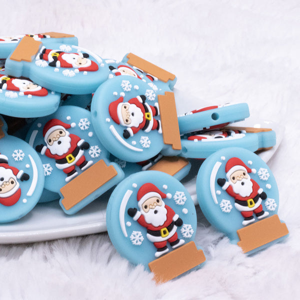 Front view of a pile of Santa Snow Globe Silicone Focal Bead Accessory