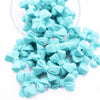 Front view of a pile of 27mm Turquoise Blue Bow Knot silicone bead