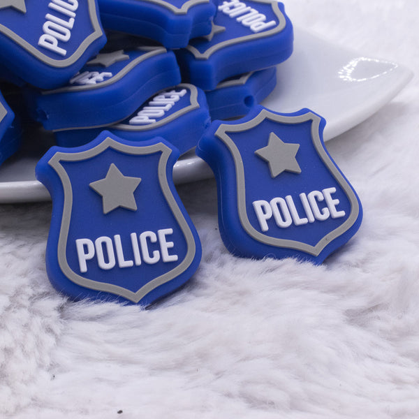 close up view of a pile of Blue Police Badge Silicone Focal Bead Accessory - 25mm x 30mm