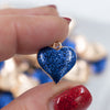 Close up view of a pile of Blue Glitter Enamel Heart Charm 15mm