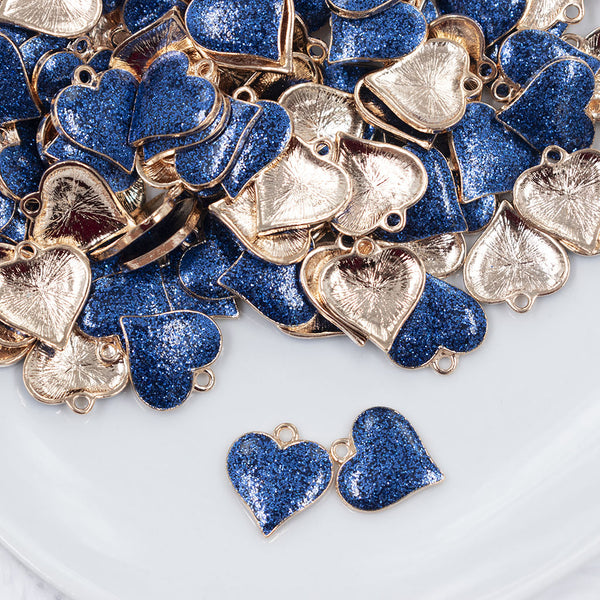 Top view of a pile of Blue Glitter Enamel Heart Charm 15mm