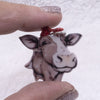 closeup view of a pile of Cow with Bow Pendant with hoop 35x27mm
