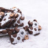 front view of a pile of Brown Cow Silicone Focal Bead Accessory - 40mm x 32mm