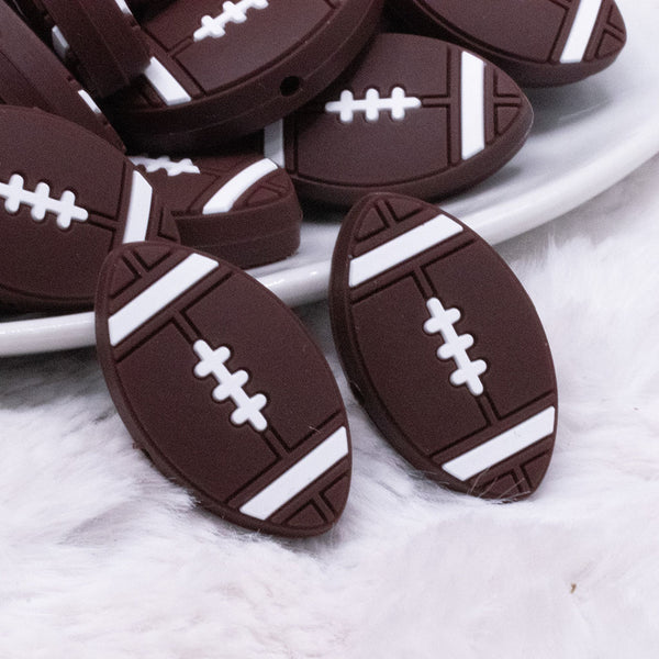 front view of a Football Silicone Focal Bead Accessory - 30mm x 18mm