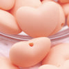 Close up view of a pile of 20mm Peach heart silicone bead