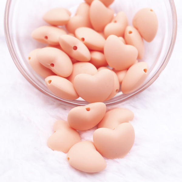 Top view of a pile of 20mm Peach heart silicone bead