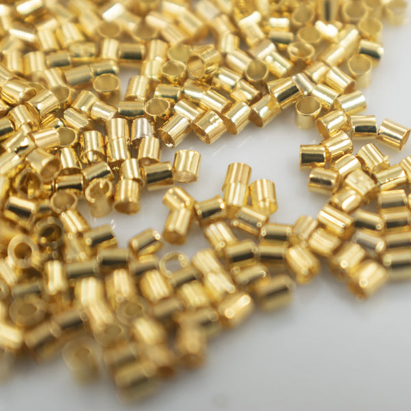 Top close up view of a pile of Close up view of a pile of 2mm Gold Crimp Tubes for Jewelry Making