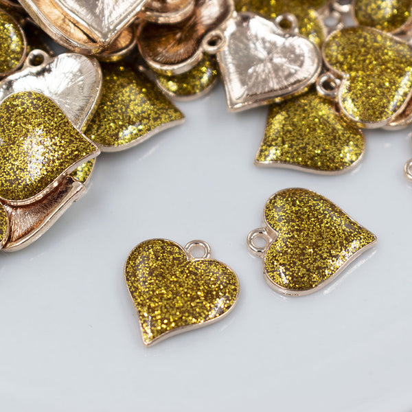 Front view of a pile of Gold Glitter Enamel Heart Charm 15mm