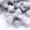 Close up view of a pile of 27mm Light Gray Bow Knot silicone bead
