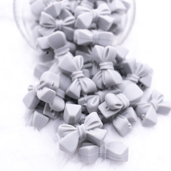 Front view of a pile of 27mm Light Gray Bow Knot silicone bead